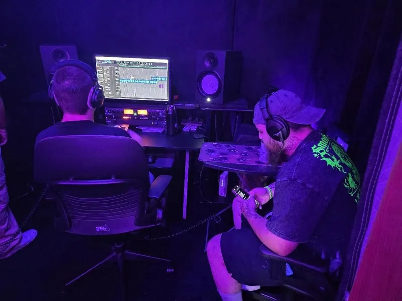 In headphones at the desk, working through the vocal takes on the screen