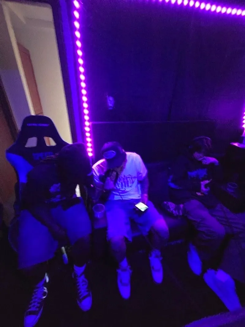 Three of the crew on the couch under the blacklight between takes