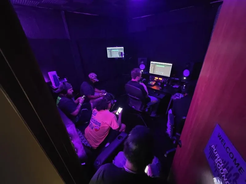 Through the door — the Welcome to Purple Sound sign and the whole room at work