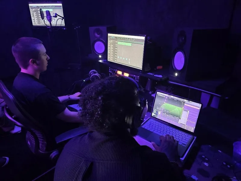Two rigs side by side — the desk on the takes, the laptop on the beat