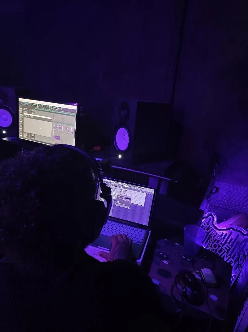The mic pulled right up to the couch — verse off the phone, straight into the take